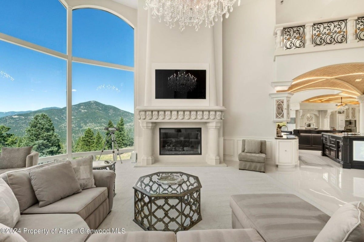 Massive arched windows frame breathtaking mountain views, making the room bright and inviting.