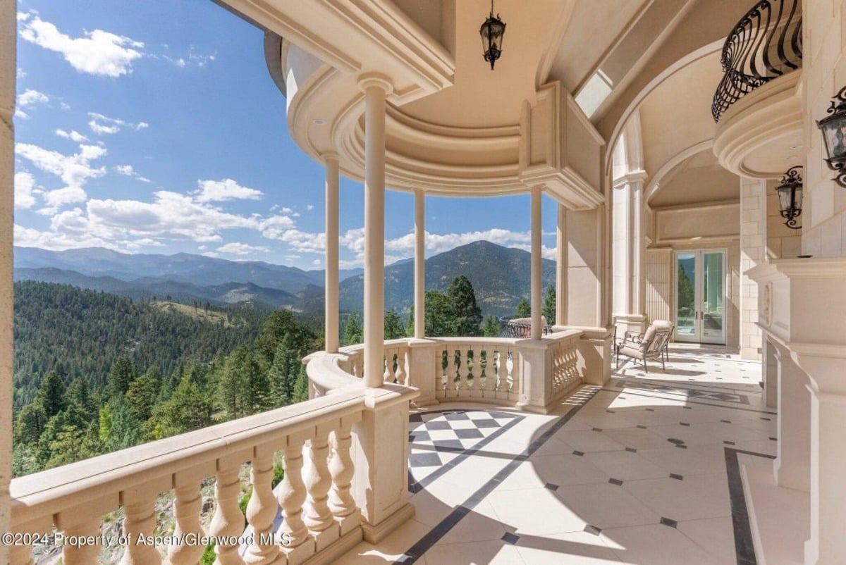 Supported by large decorative columns, the balcony features arched ceilings and open-air seating areas.