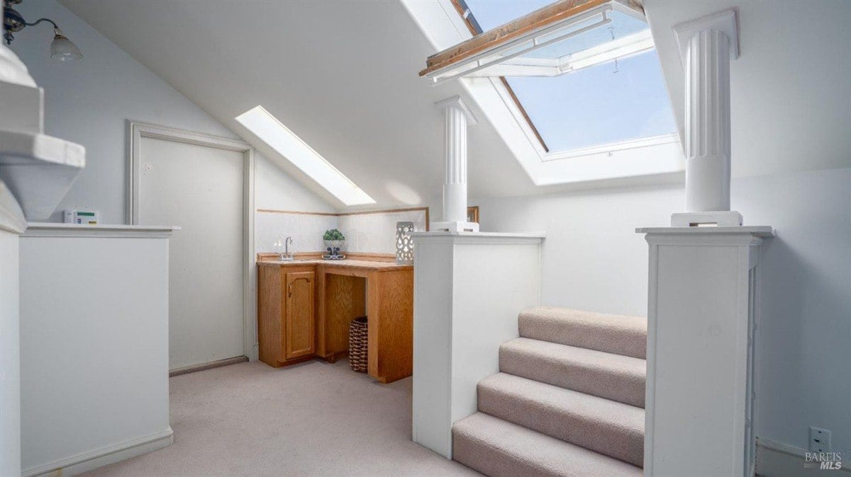 Skylight brings natural light to an upper-level landing with a built-in counter and sink.