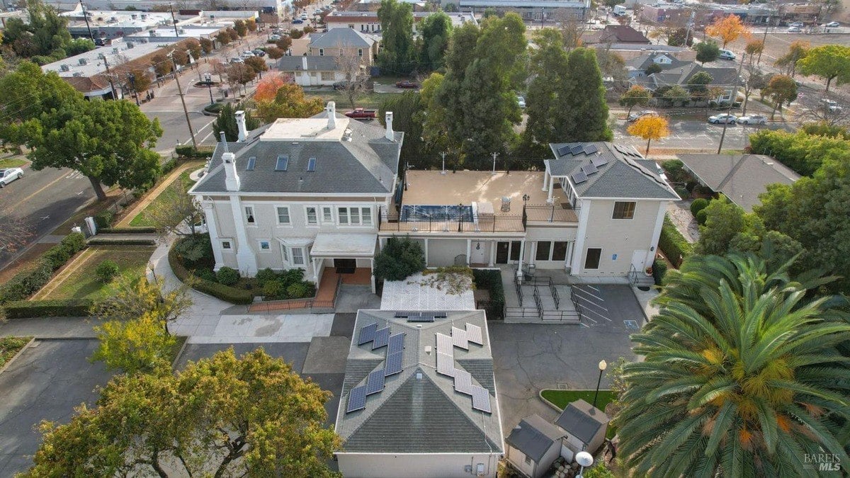 Overhead view highlights the main property, solar panels, and surrounding neighborhood layout.
