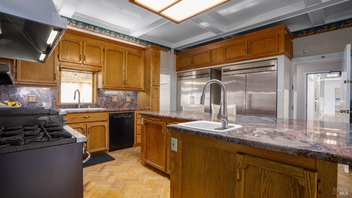 Spacious kitchen with warm wood cabinetry, built-in stainless steel appliances, and a granite island sink.