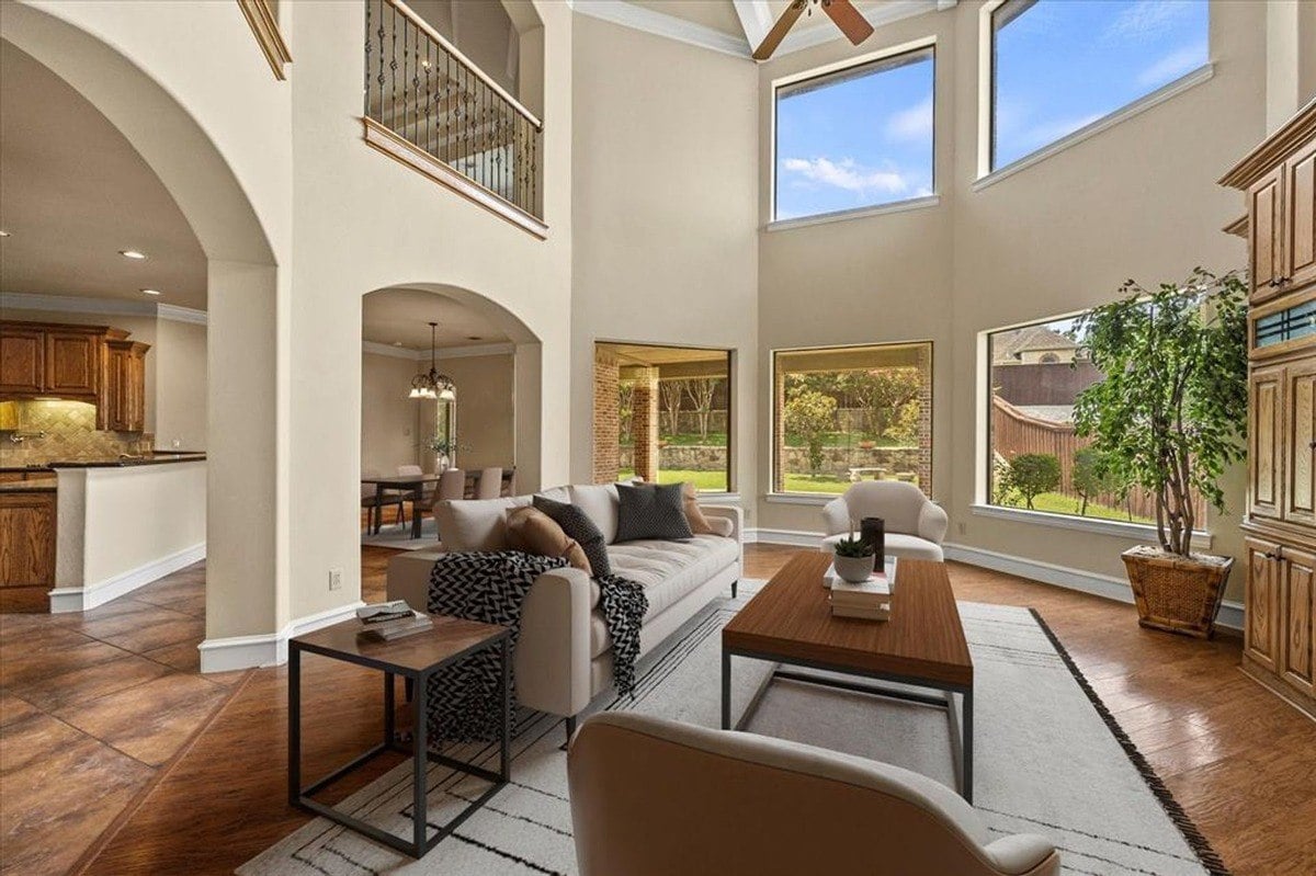 Open-concept living area with staged furniture, highlighting a connected view to dining and kitchen spaces.