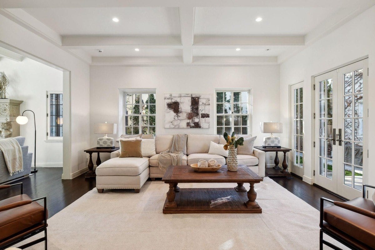Living room with a large sectional sofa, coffee table, and hardwood floors.