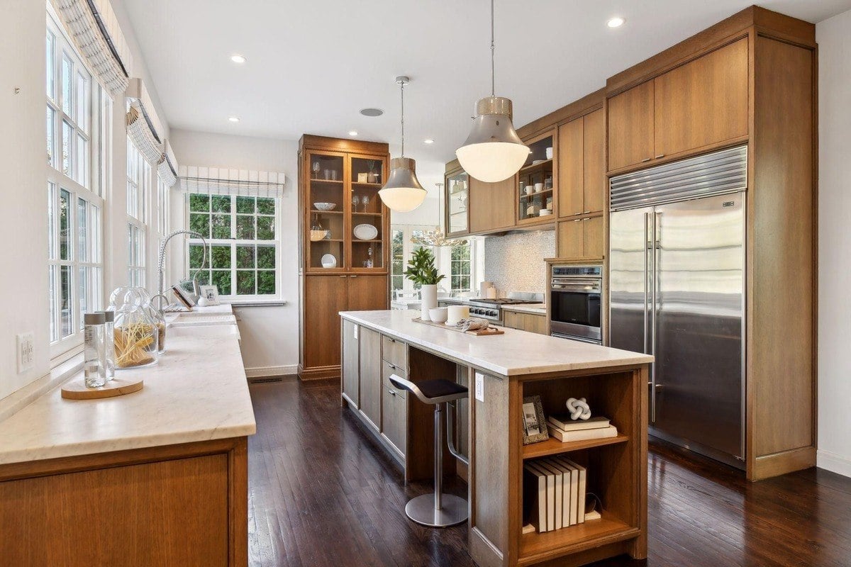 Kitchen with wood cabinets, marble countertops, and stainless steel appliances.