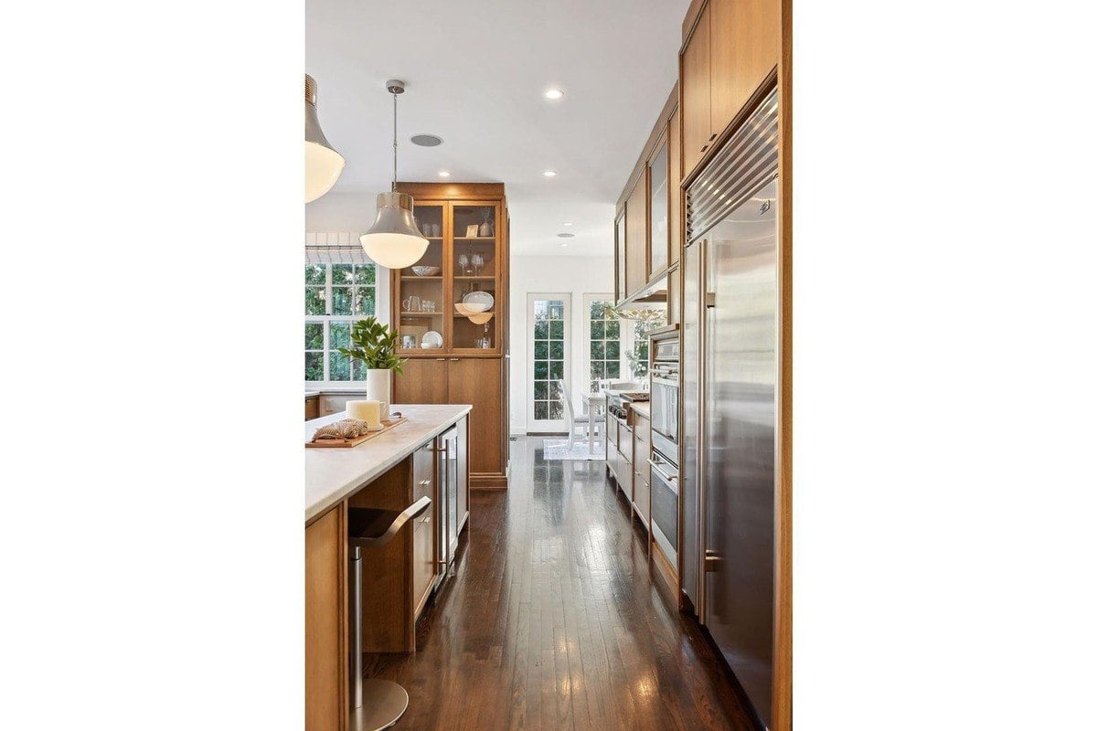 Kitchen with wood cabinets, marble countertops, and stainless steel appliances.