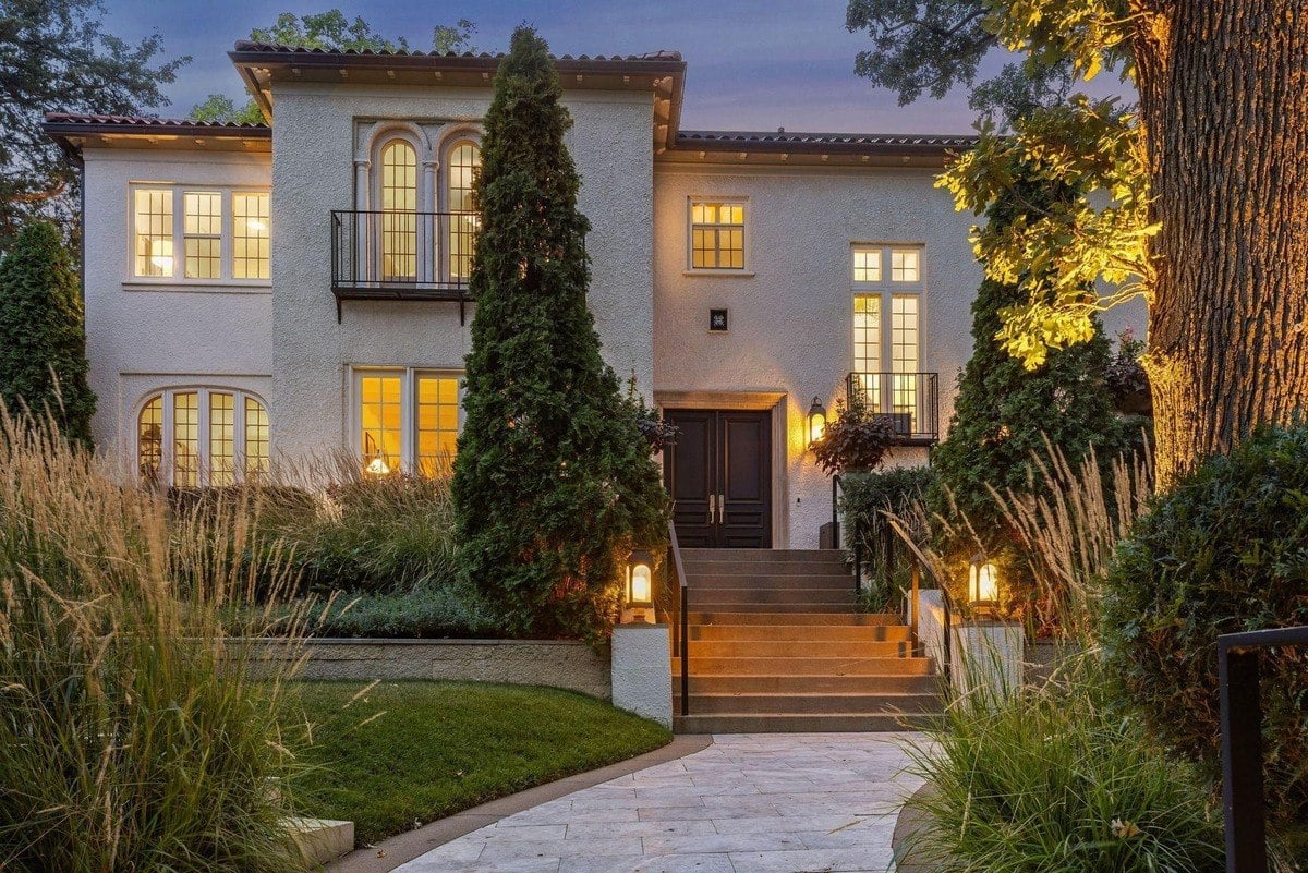 Large white stucco house with a red tile roof, and a walkway leading to the entrance.