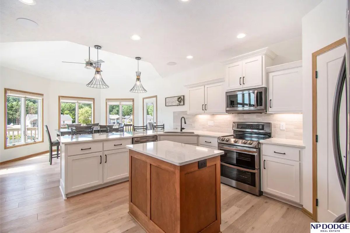 A central island with contrasting wood tones and a quartz countertop.