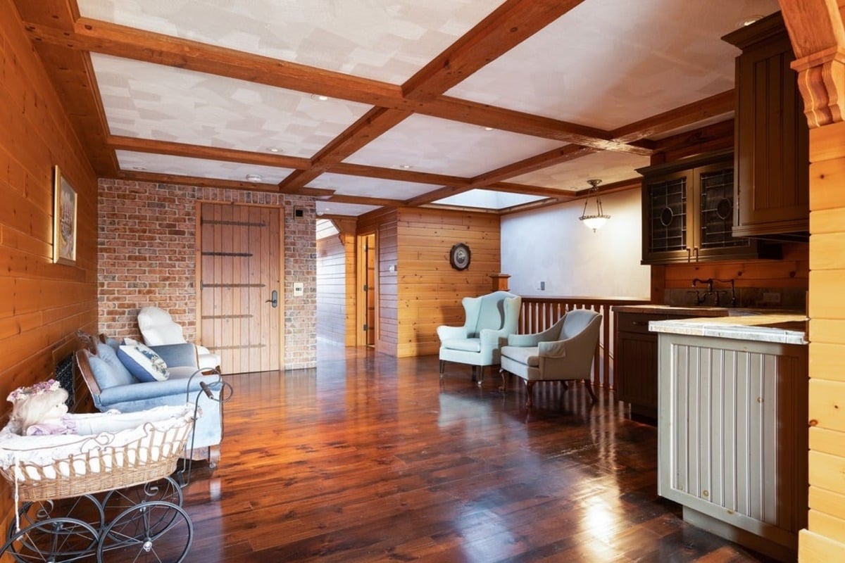 Sitting area with wood-paneled walls and a brick accent exudes rustic charm and comfort.