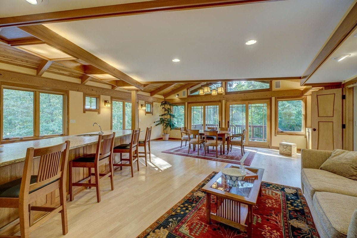 Open-concept living area features a vaulted ceiling, a well-equipped kitchen, and a dining area, creating a warm and inviting atmosphere.