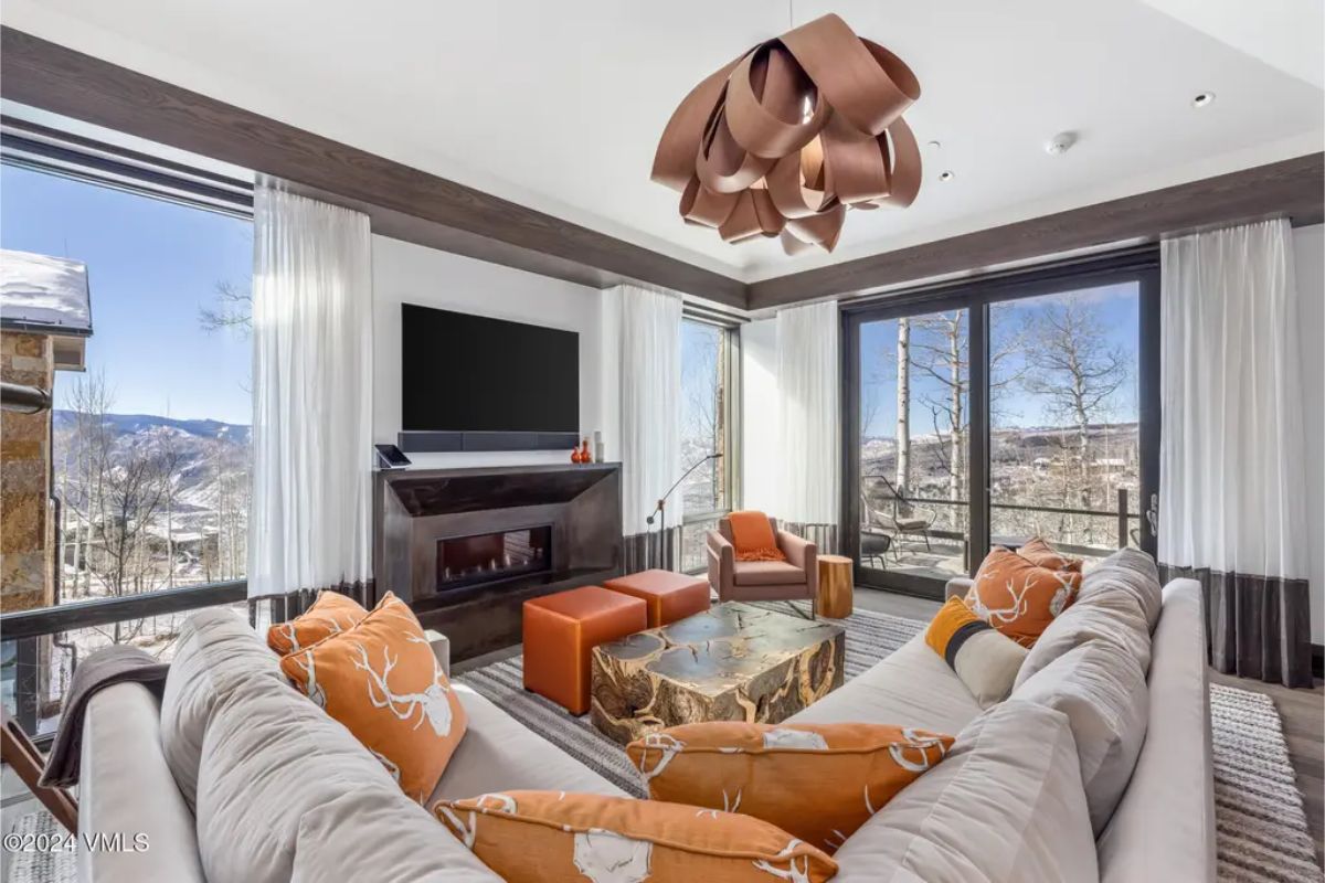 Cozy lounge area features floor-to-ceiling windows that provide unobstructed views of the surrounding mountains
