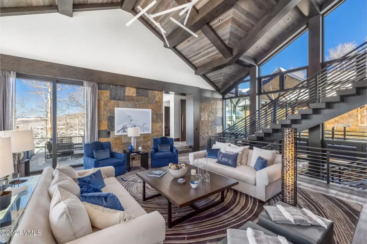 A blend of contemporary architecture and natural materials. A striking open staircase with sleek railings complements the vaulted ceilings and large windows.
