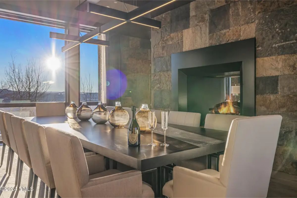 A sophisticated dining area with a dark rectangular table surrounded by plush upholstered chairs.
