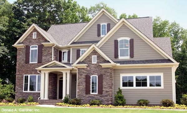 Elegant Two-Story Home with Stone Facade and Charming Shutters
