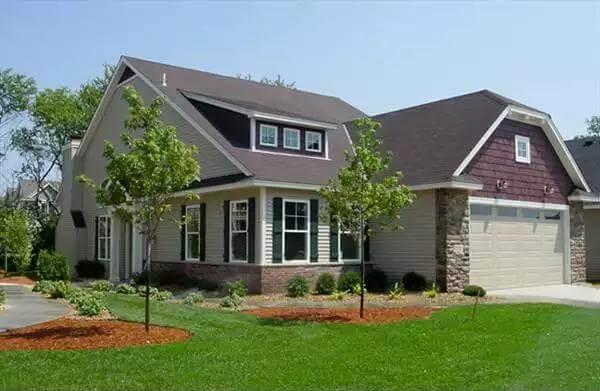 Charming Suburban Home with Stone Accents and Dormer Windows