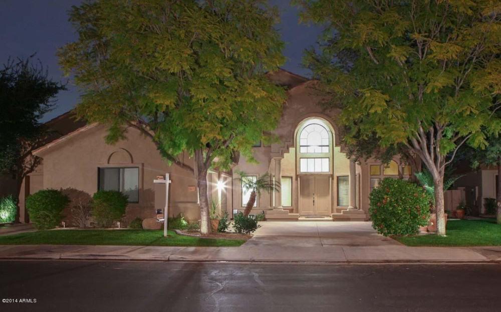 Grand Entrance with Arched Windows and Lush Landscaping