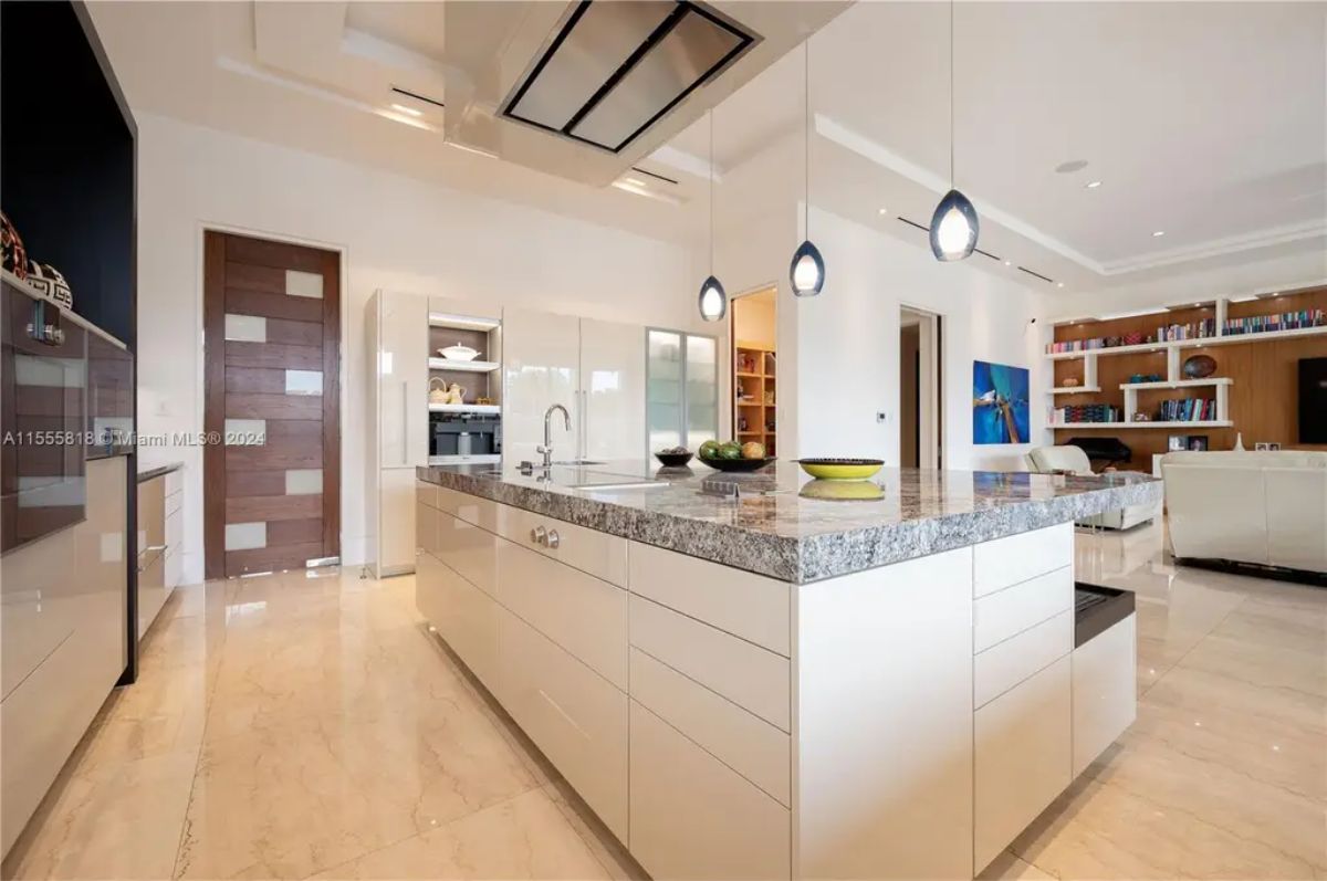 A secondary view of the kitchen showcases custom cabinetry, an integrated pantry, and a transition into a cozy lounge area with built-in shelves. 
