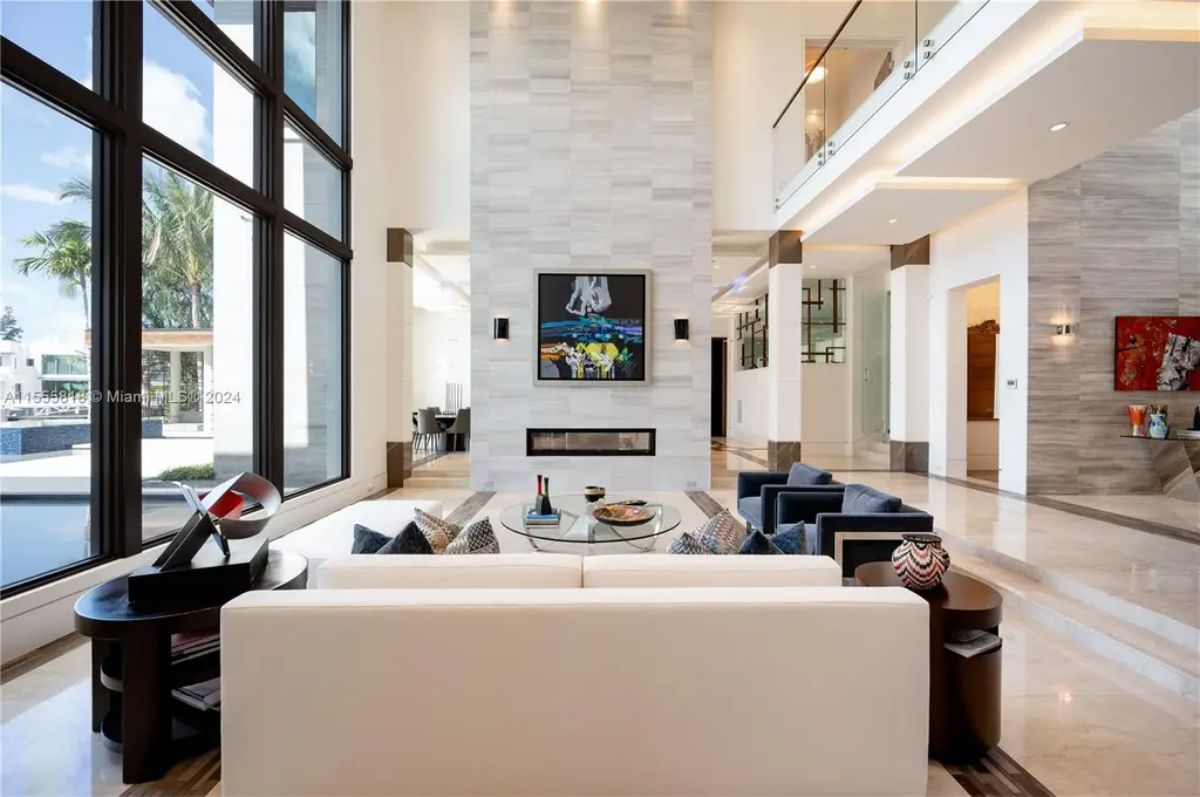 Elegant interior design elements include a white and navy-blue seating area, a modern fireplace, and sophisticated artwork. 