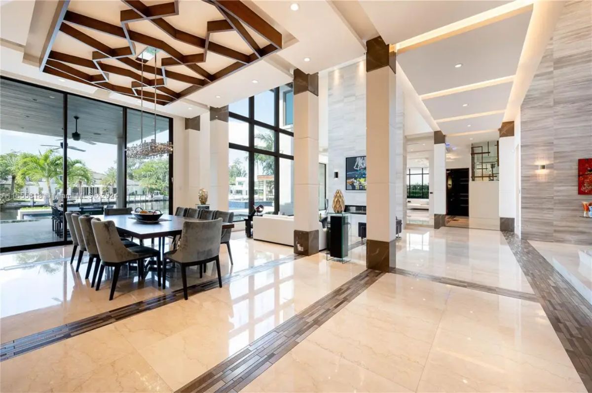 A seamless open-concept design connects the formal dining area, living room, and grand staircase, emphasizing luxury and spaciousness. 