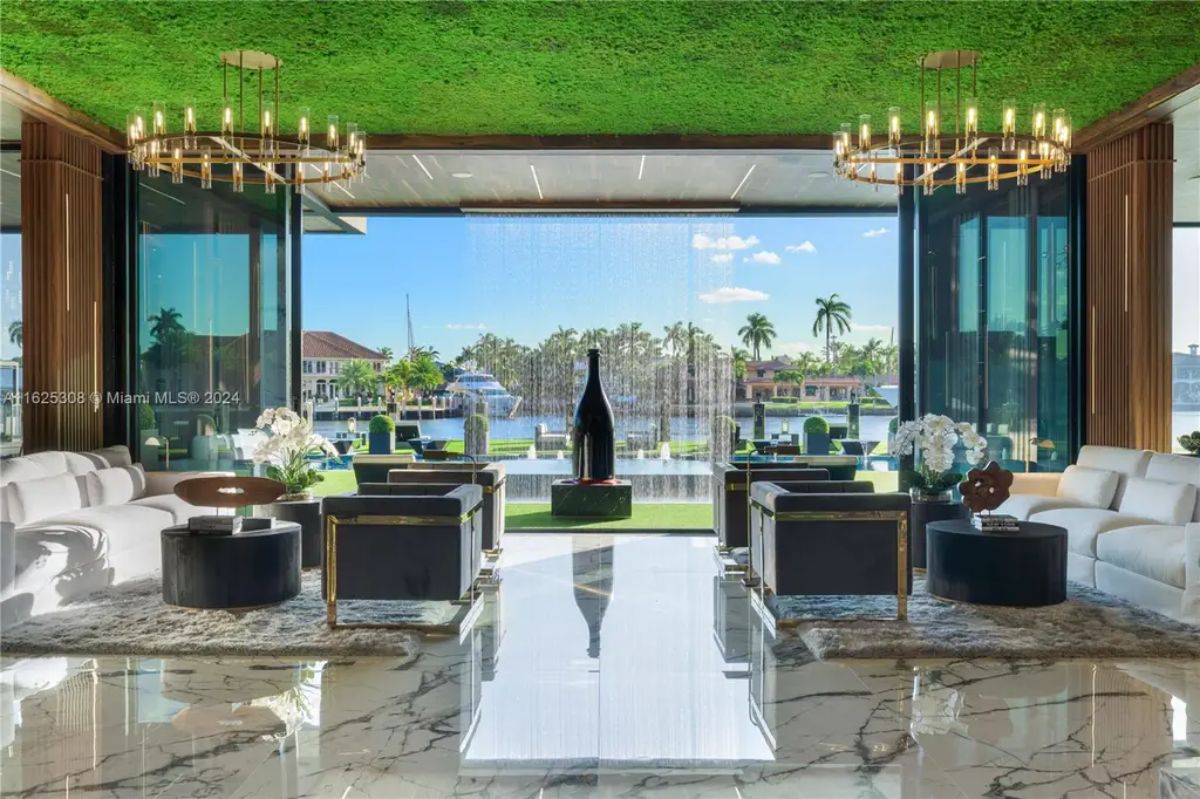 Open-concept living area features marble flooring, plush seating, and gold-accented chandeliers.