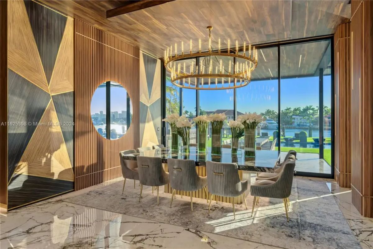 Glass dining table with plush upholstered chairs sits atop a marble floor with a textured area rug.