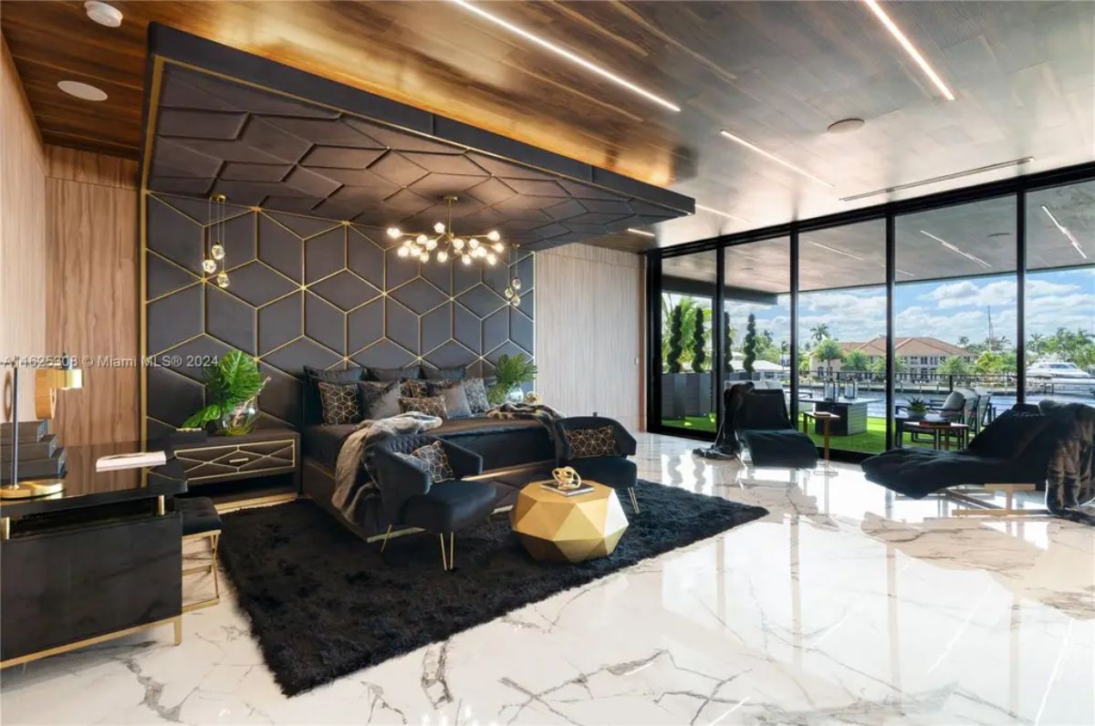 Black and gold geometric accent wall extends to the ceiling, framing the plush king-size bed.