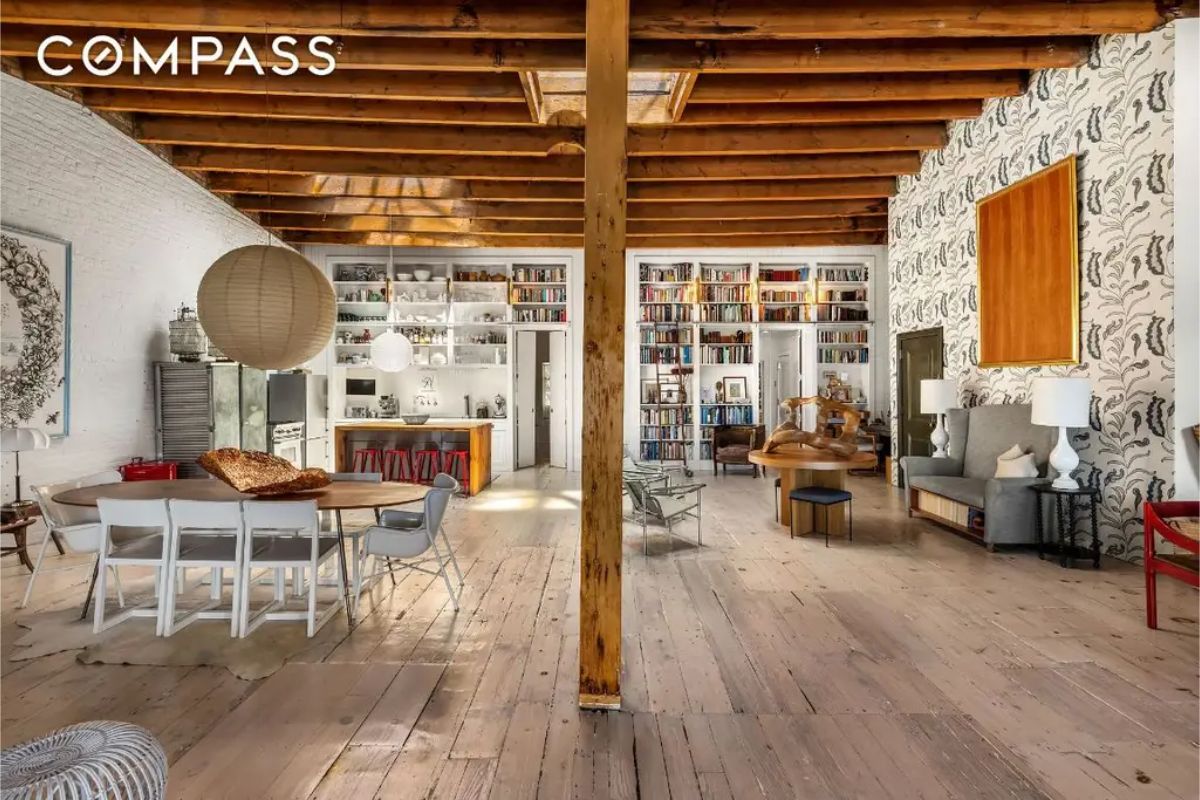 Open-concept living space with exposed wooden beams and a skylight.