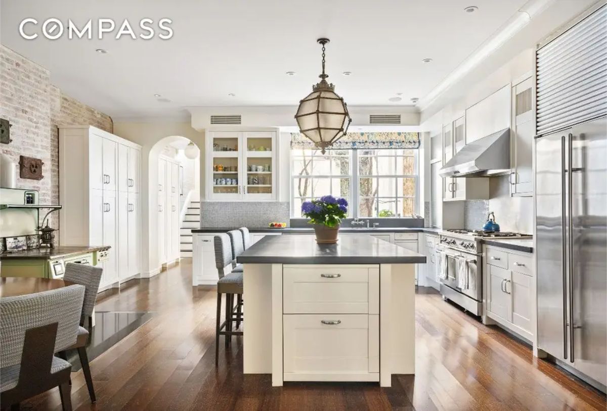 Spacious kitchen with white cabinetry, stainless steel appliances, and a large island.