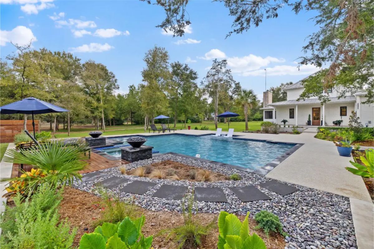 Backyard with a large swimming pool, built-in spa, and modern water features.