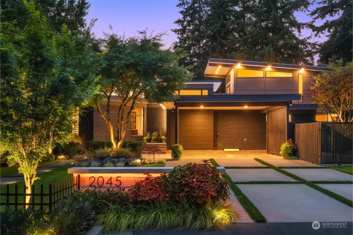 Contemporary house entrance illuminated by warm lighting with a sleek architectural design. 