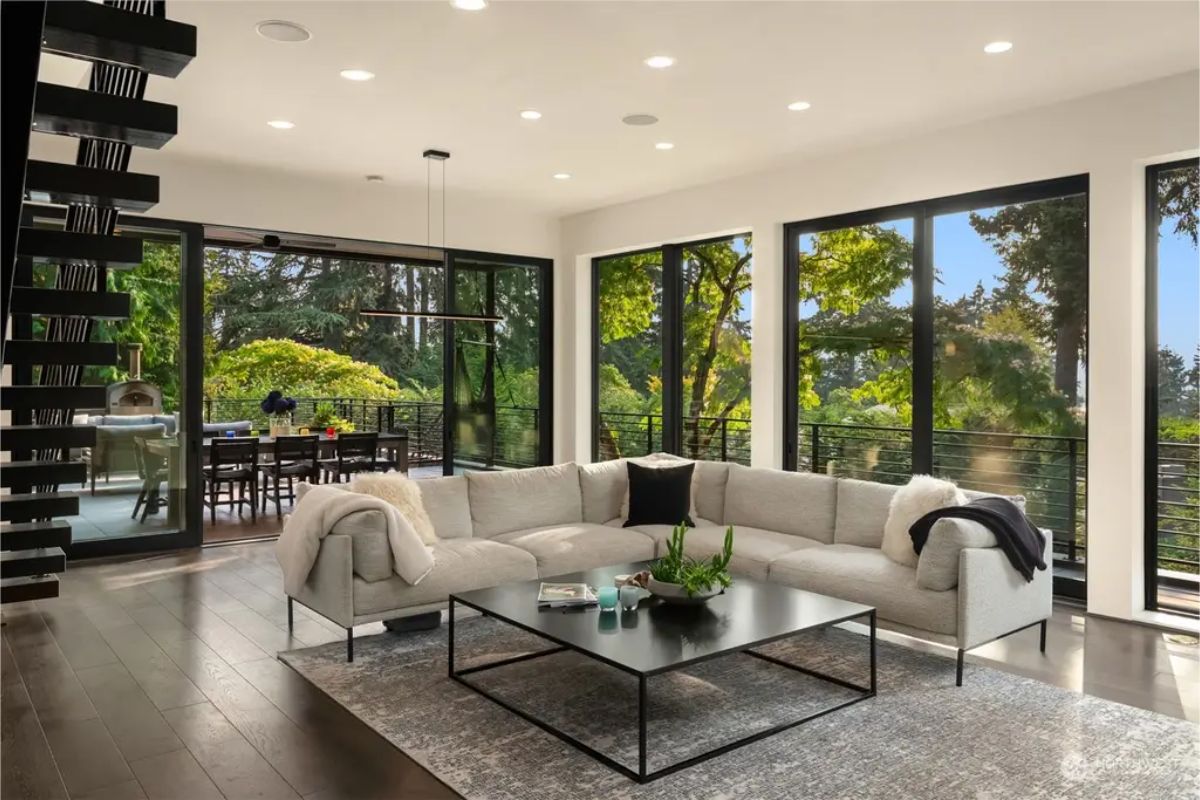 Spacious lounge area connected to an outdoor dining space through large glass doors. 