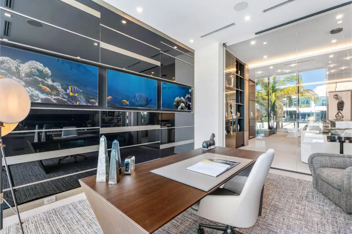 Modern home office with a sleek desk, ergonomic chair, and vibrant underwater-themed wall art. 