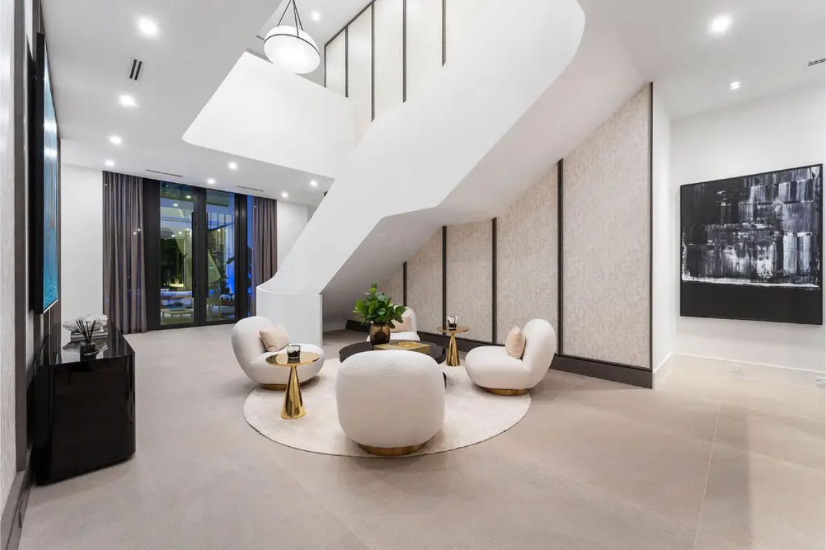 Elegant sitting room with cozy armchairs, modern art, and an open view to the outdoor patio. 