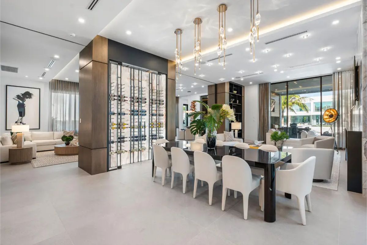 Spacious dining area seamlessly blending into the living room, adorned with modern art and floor-to-ceiling windows for natural light. 