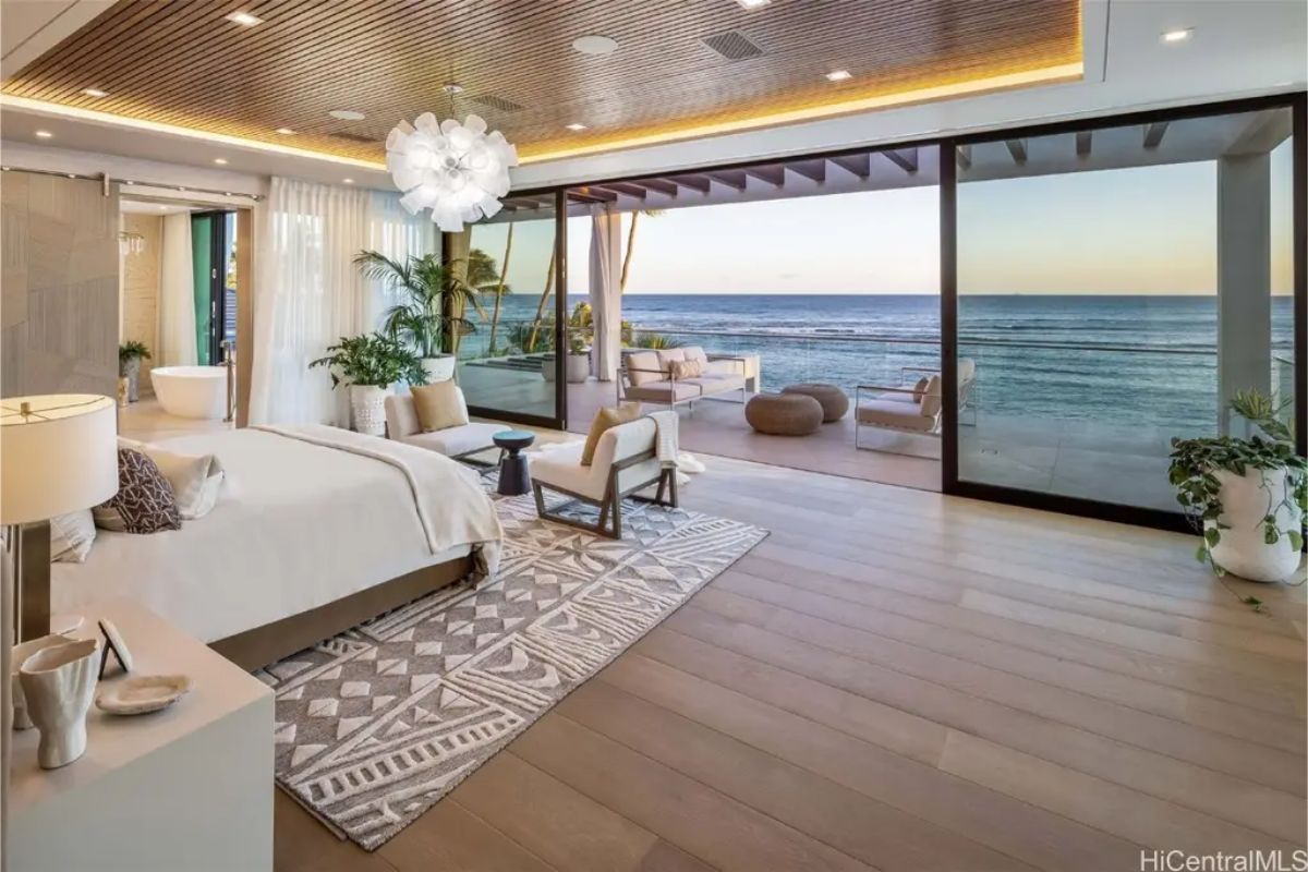 Luxurious primary bedroom extends to a private balcony with panoramic ocean views and a spa-like ensuite. 