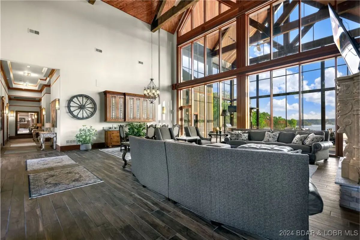 Spacious living area with high ceilings, exposed beams, and floor-to-ceiling windows.