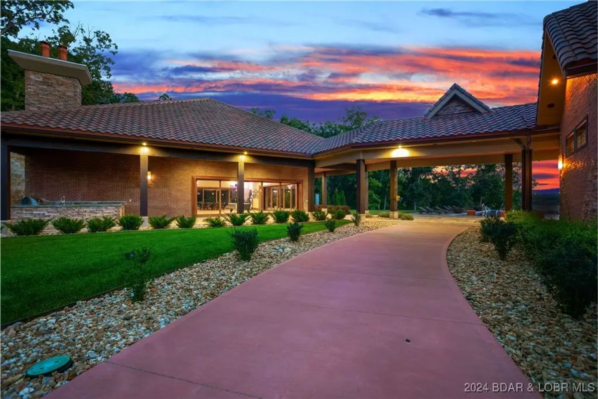 Brick and wood exterior with a covered driveway leading to the entrance.