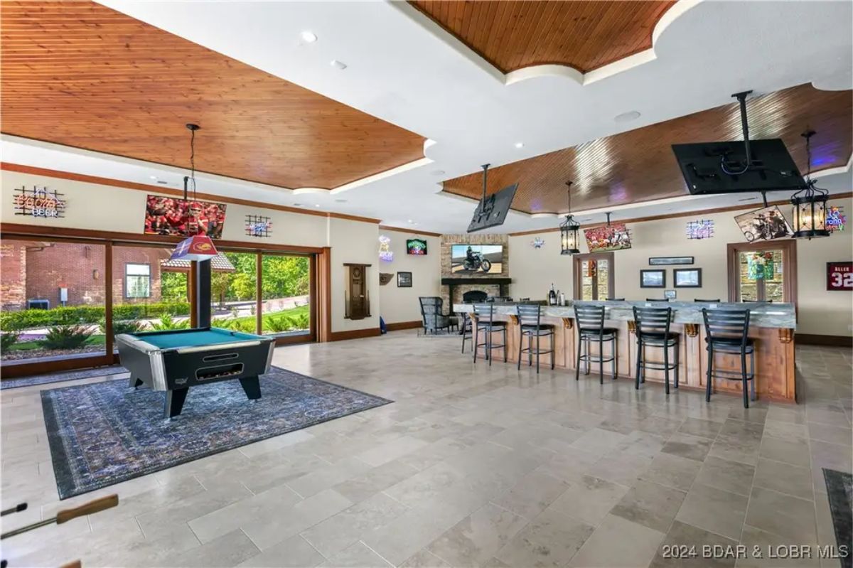 Open recreation area with a bar, pool table, and multiple televisions.