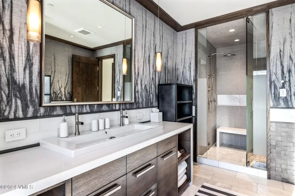 Sleek double vanity with white countertops, dark wood cabinetry, and under-sink storage.