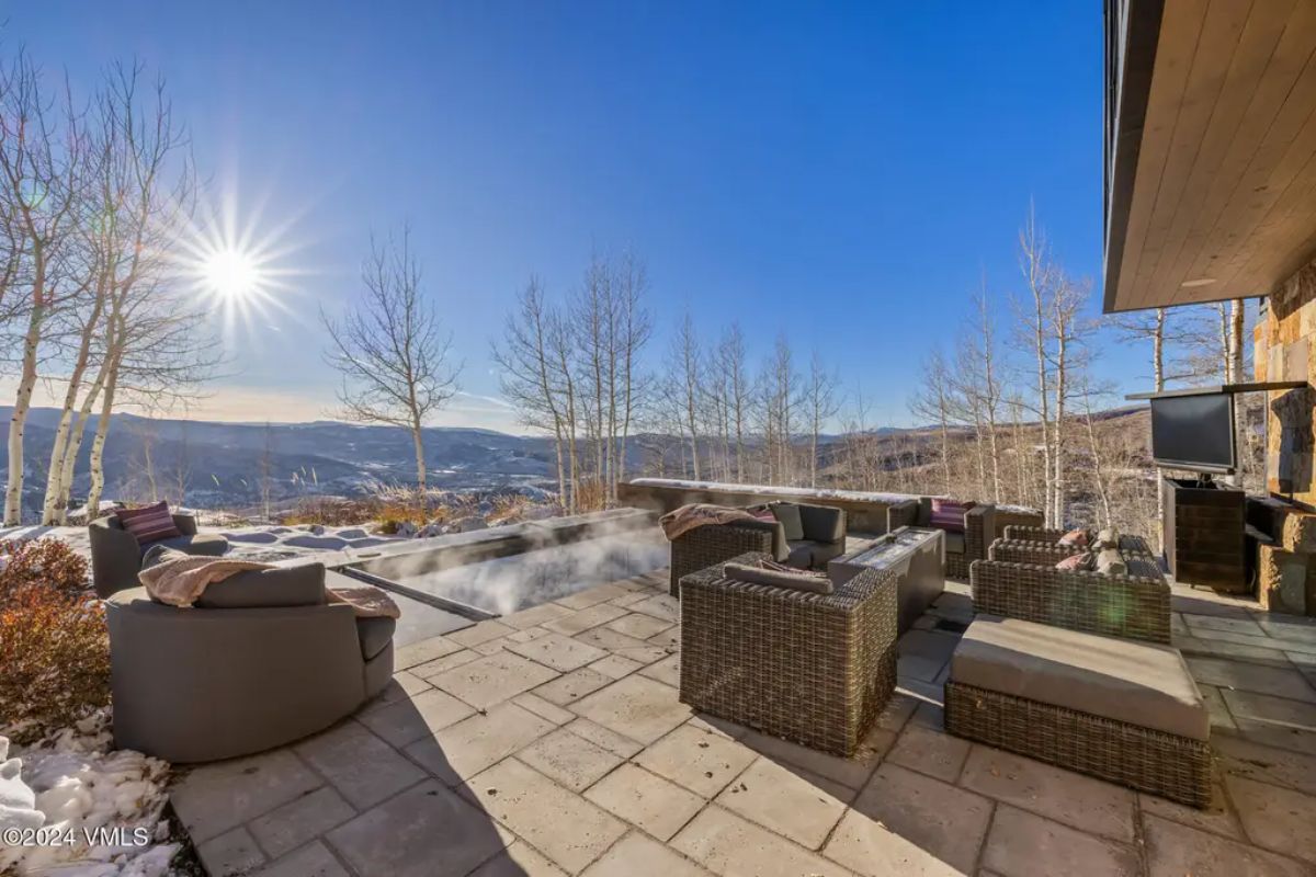 Wicker seating with cushioned chairs and a central fire pit.