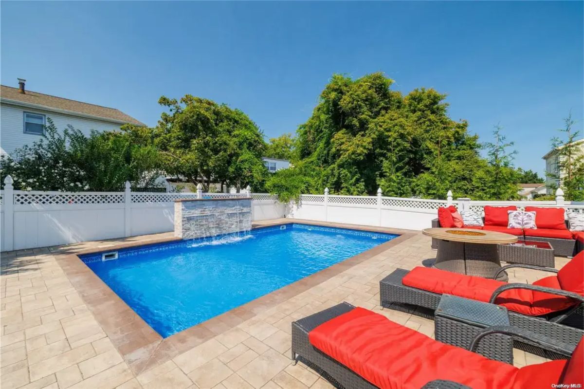 Rectangular in-ground pool features a cascading waterfall.