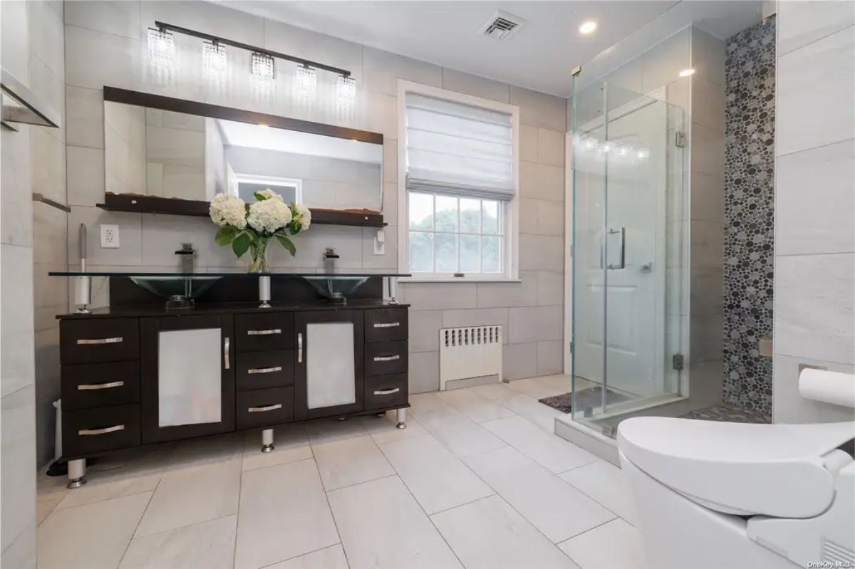 A double vanity with glass vessel sinks provides a modern touch.