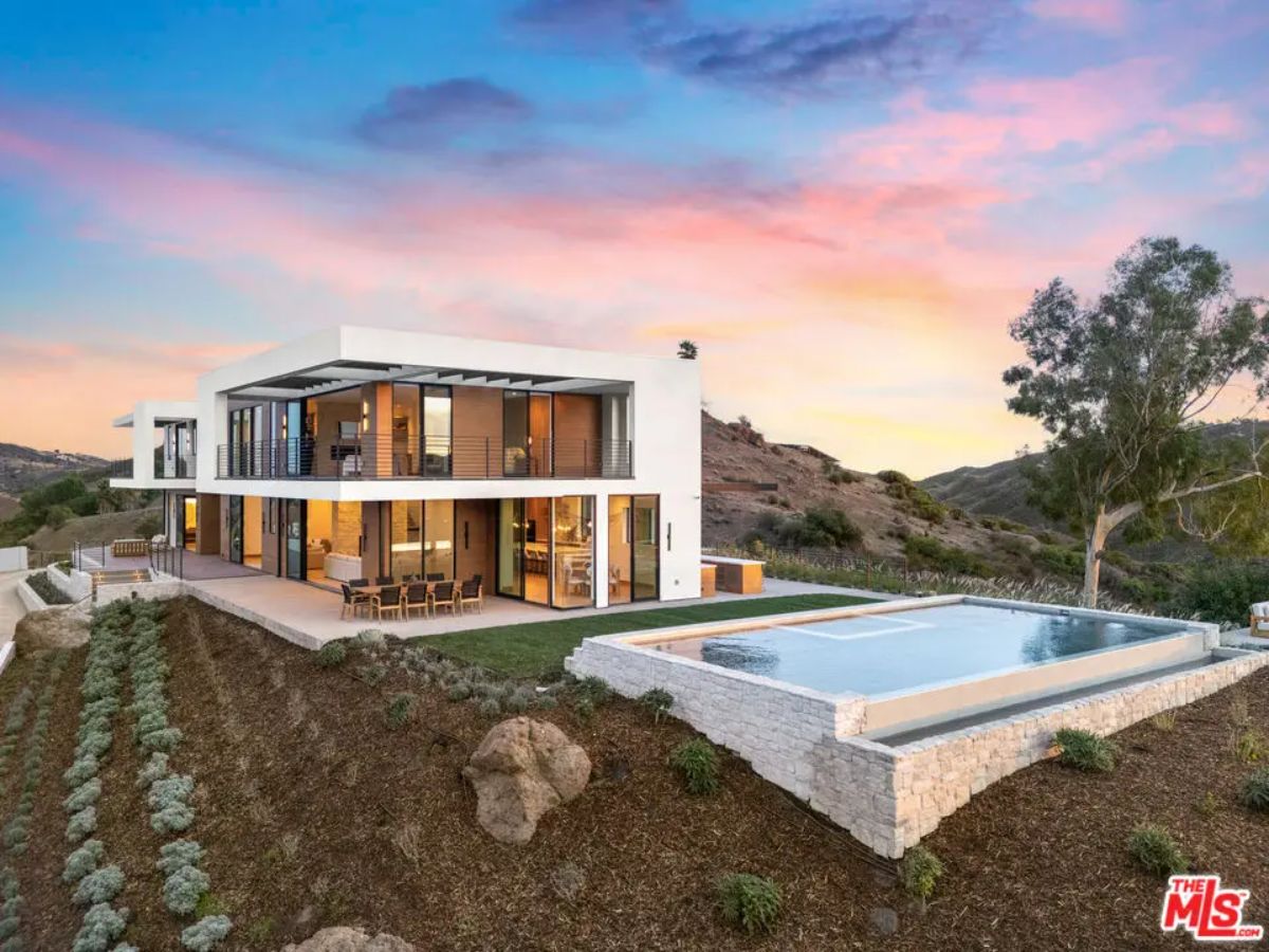Two-story contemporary home with floor-to-ceiling glass windows and open-concept design.