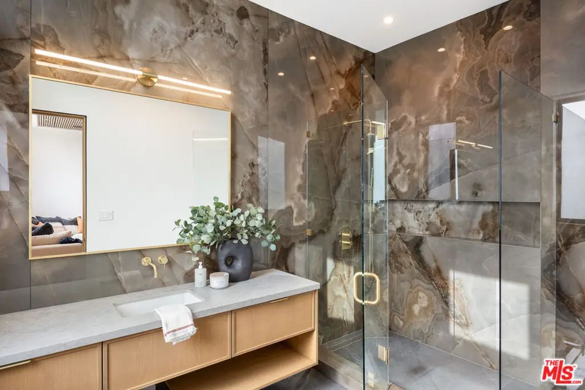 Bathroom with floor-to-ceiling marble walls in rich earth tones.