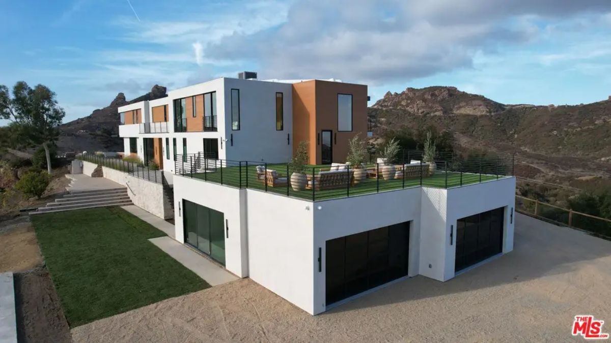 Contemporary multi-level home with white stucco and wood paneling.