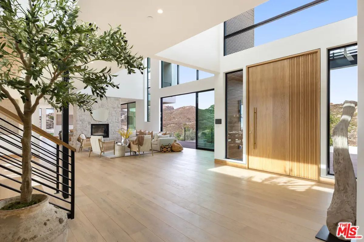 Spacious foyer with high ceilings and floor-to-ceiling windows brings in natural light