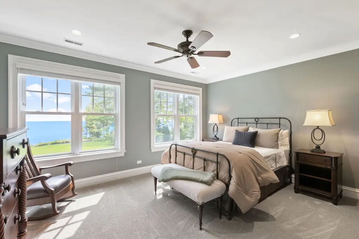Large windows offering scenic views of a lush lawn and a tranquil lake.