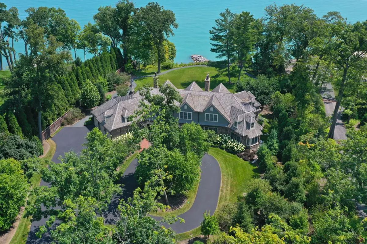Expansive home sits on a wooded lot with direct access to a bright blue lake.