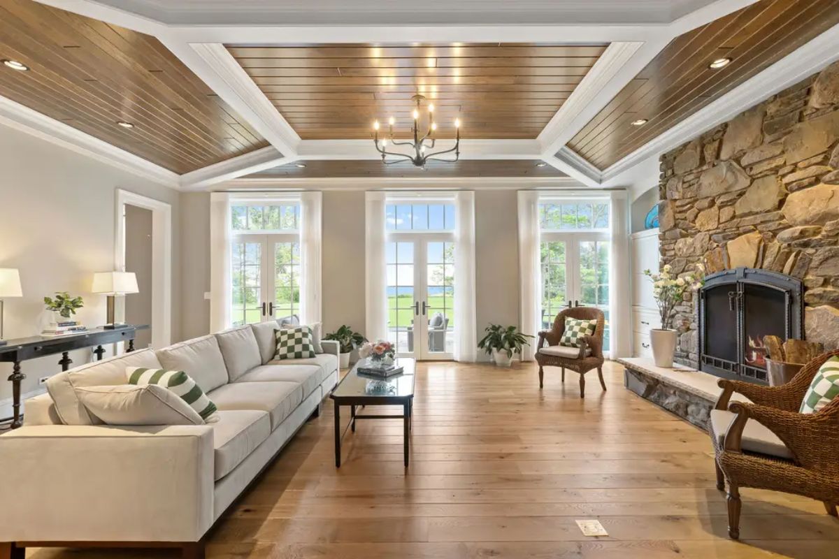 Wide-plank hardwood floors and a coffered ceiling featuring wood panel insets and white trim.