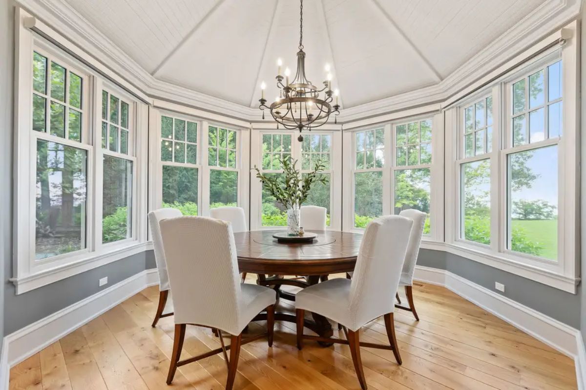 Octagonal dining area surrounded by large windows offers abundant natural light and scenic outdoor views.