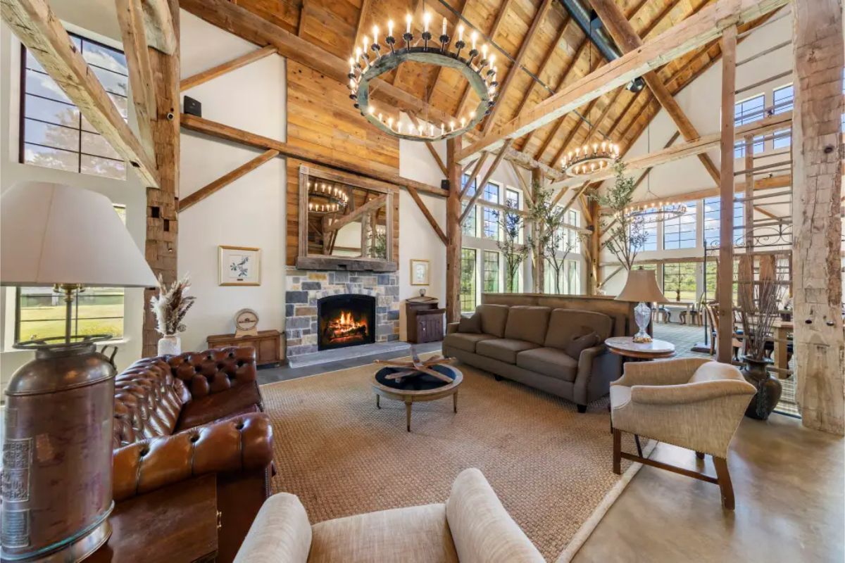 Living room with high ceilings, wooden beams, and large windows.
